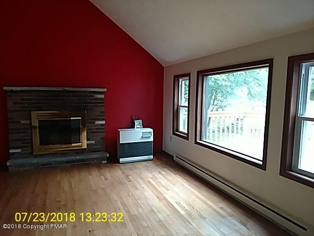 263 Canterbury Road Bushkill, PA 18324 - Photo 2 of 16 a living room with a fireplace and a large window