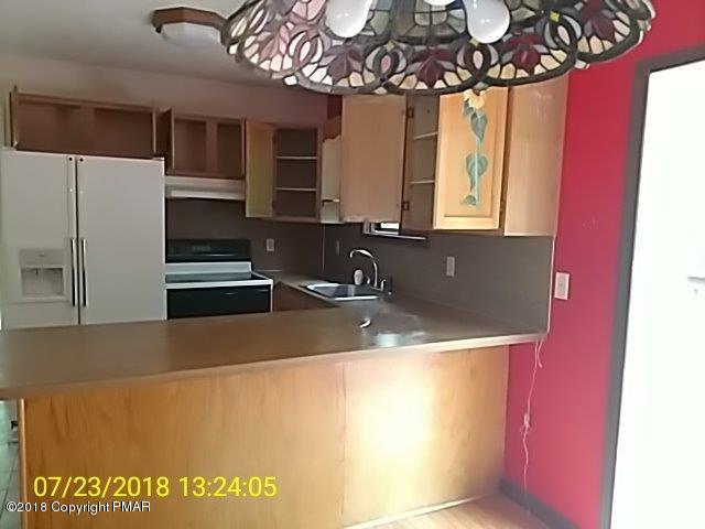 263 Canterbury Road Bushkill, PA 18324 - Photo 6 of 16 a kitchen with a sink a microwave and cabinets