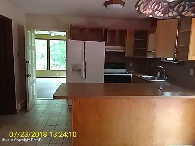 263 Canterbury Road Bushkill, PA 18324 - Photo 7 of 16 a kitchen with a sink and a refrigerator