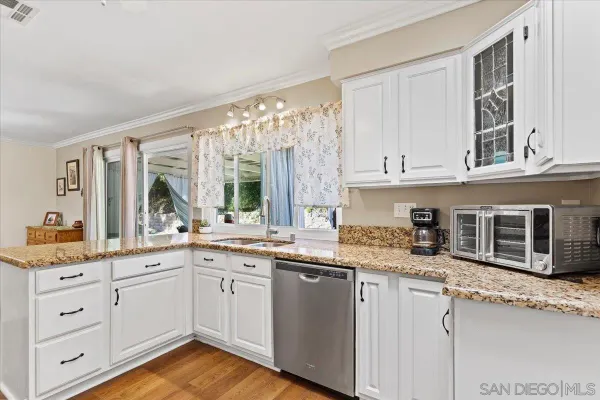 a kitchen with stainless steel appliances granite countertop a stove and a white cabinets