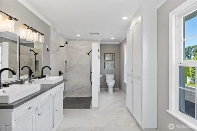 a spacious bathroom with a double vanity sink a mirror and a shower