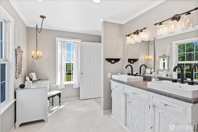 a bathroom with double vanity sink a two mirror a window and a bathtub