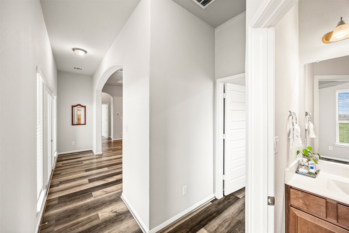 11202 Seguin Trail Needville, TX 77461 - Photo 18 of 31 a view of a hallway with wooden floor and a bathroom