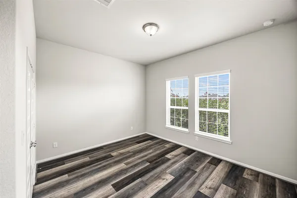 a view of a room with wooden floor and windows