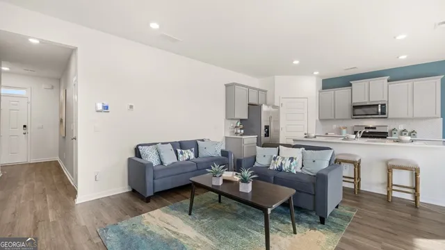 a living room with kitchen island furniture and a kitchen view