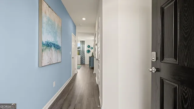 a view of hallway with stairs and wooden floor