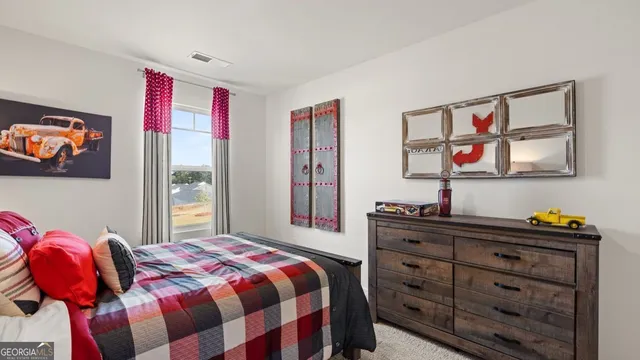 a bedroom with a bed and a dresser in it