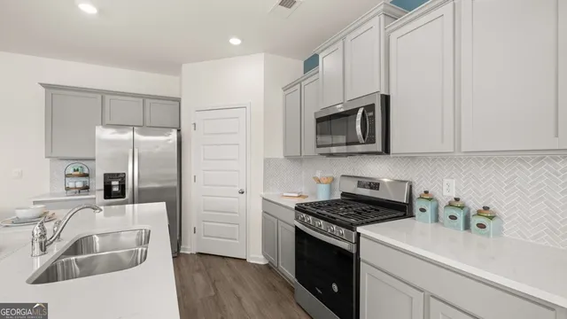 a kitchen with stainless steel appliances granite countertop a sink stove and refrigerator