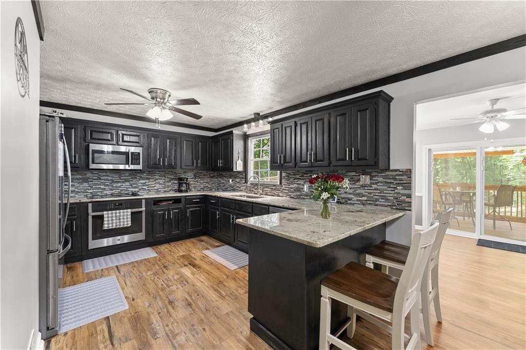 1405 Tapp Wood Road Hoschton, GA 30548 - Photo 11 of 44 a kitchen with stainless steel appliances granite countertop a sink stove and cabinets