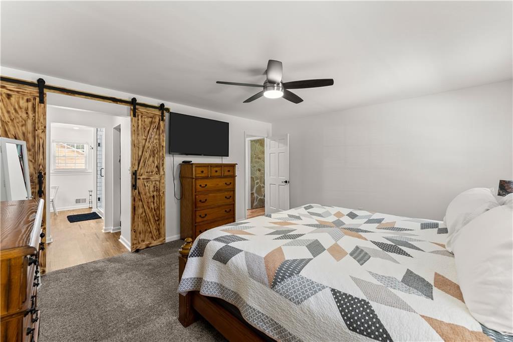 1405 Tapp Wood Road Hoschton, GA 30548 - Photo 23 of 44 a bedroom with a bed dresser and a flat tv screen