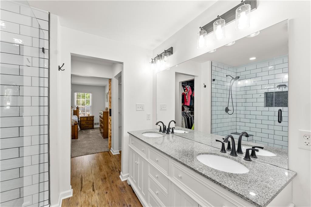 1405 Tapp Wood Road Hoschton, GA 30548 - Photo 25 of 44 a bathroom with a granite countertop sink a mirror and shower