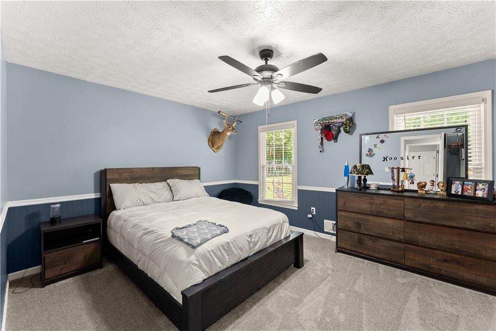 1405 Tapp Wood Road Hoschton, GA 30548 - Photo 27 of 44 a bedroom with a bed and a chandelier