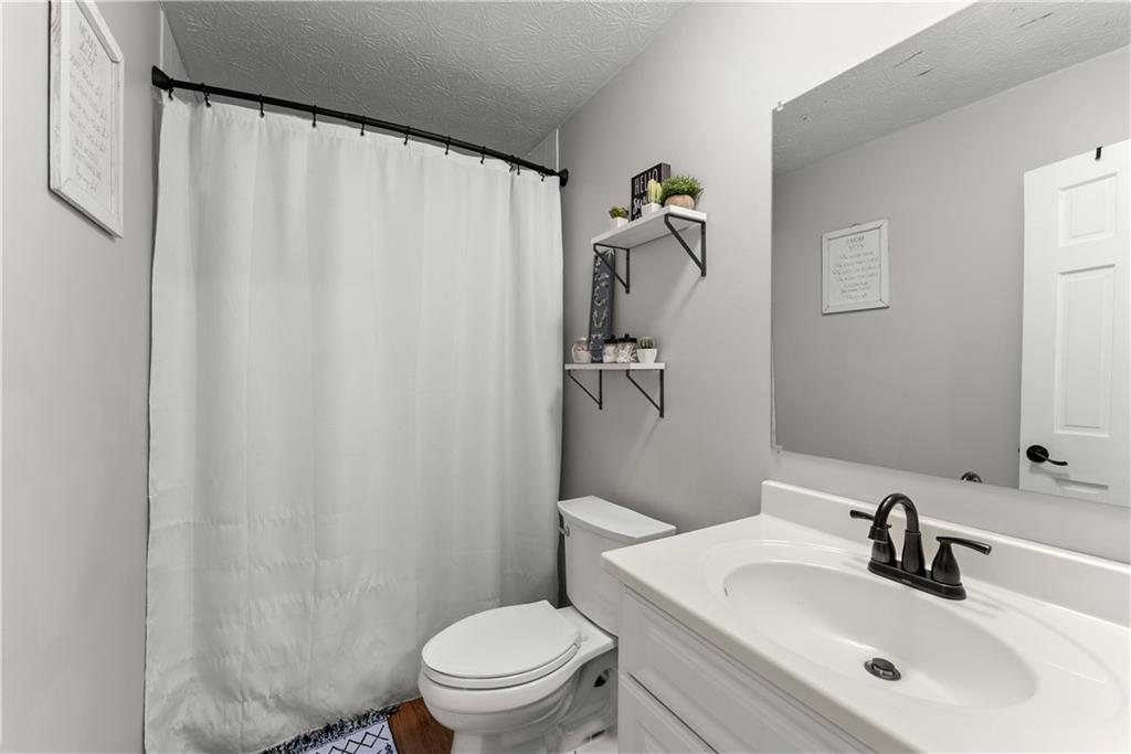 1405 Tapp Wood Road Hoschton, GA 30548 - Photo 31 of 44 a bathroom with a sink a toilet and shower curtain