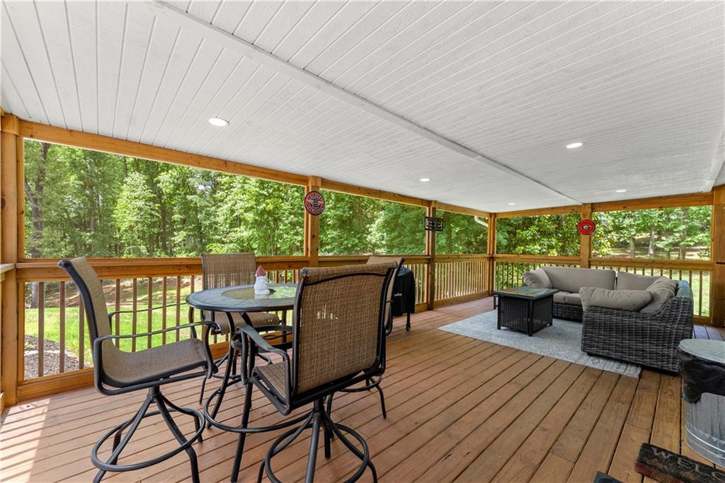 1405 Tapp Wood Road Hoschton, GA 30548 - Photo 37 of 44 a dining room with furniture wooden floor and garden view