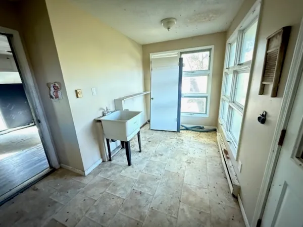 a view of an empty room with window and wooden floor
