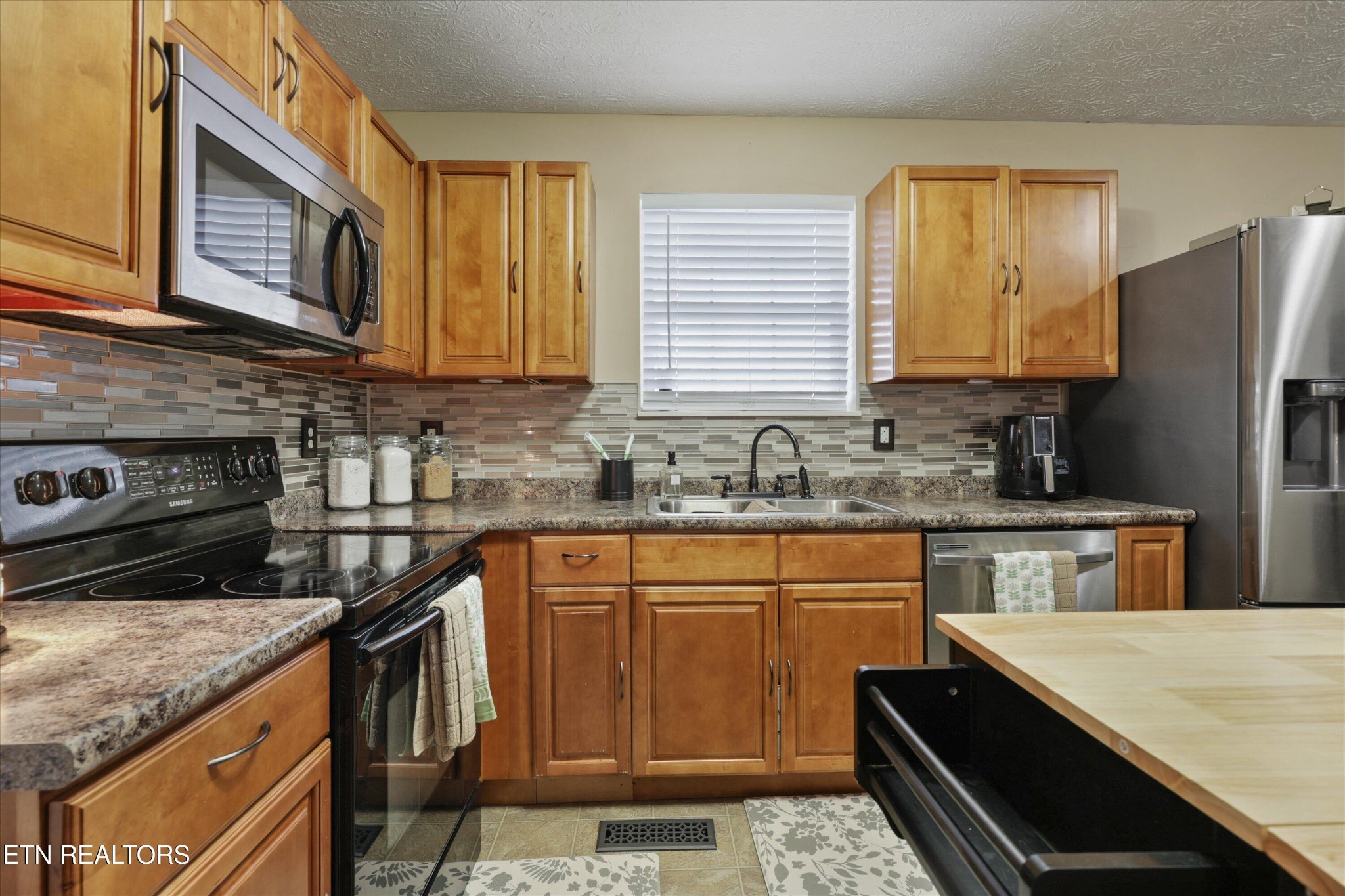 1306 Tabitha Drive White Pine, TN 37890 - Photo 11 of 31 a kitchen with stainless steel appliances granite countertop a sink stove and refrigerator