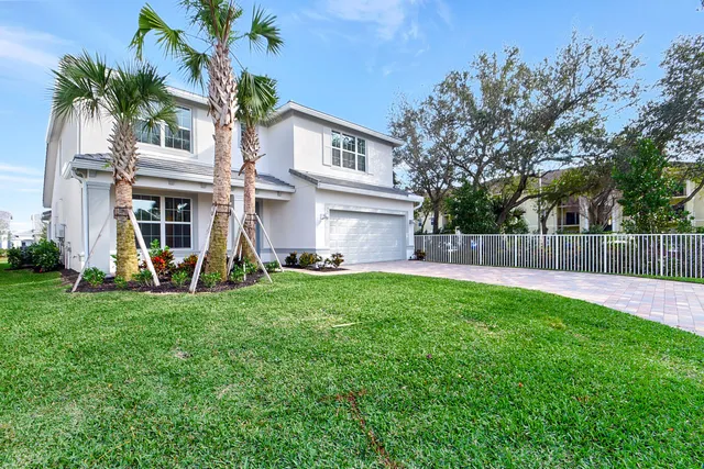 a view of a house with backyard and a tree
