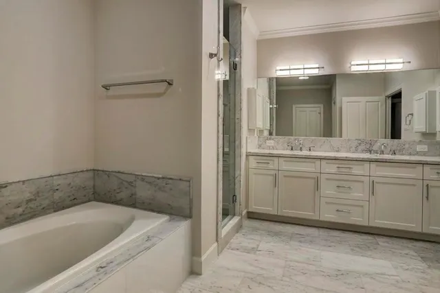 a bathroom with a granite countertop sink mirror and bathtub