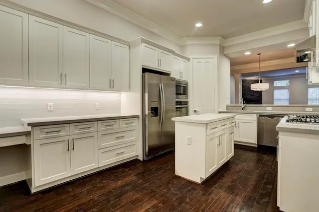 a kitchen with white cabinets and stainless steel appliances