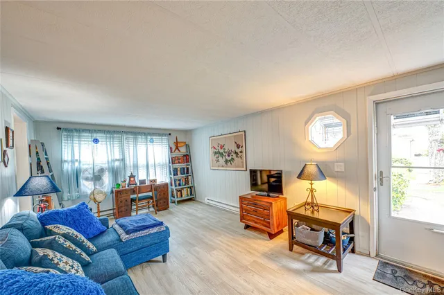 a living room with furniture flat screen tv and windows