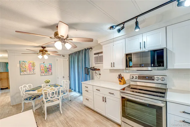 a kitchen with a stove a microwave and white cabinets