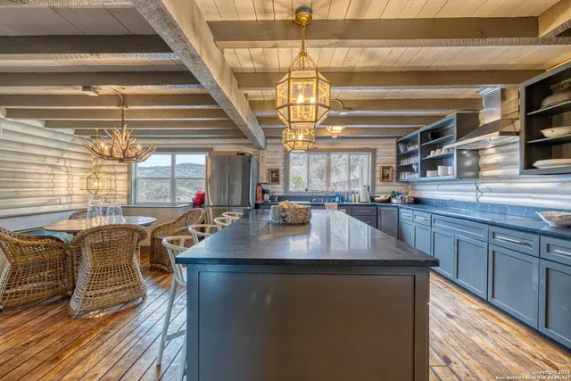 a dining table with chairs and kitchen view