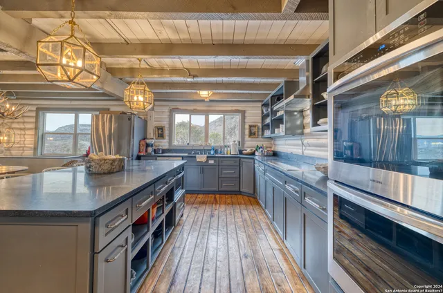 a view of a kitchen with kitchen island a large counter space a sink and appliances