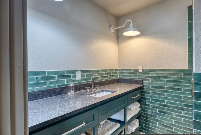 a bathroom with a granite countertop sink and a mirror