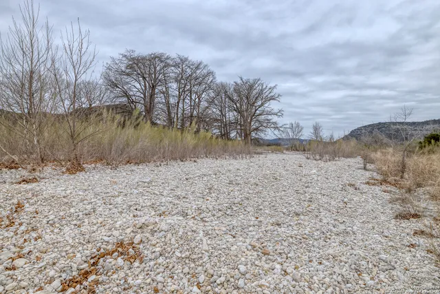 a view of a dry yard with mountains in the background