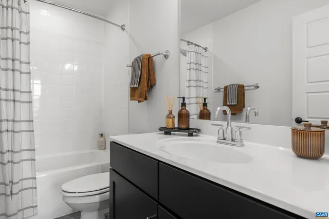 a bathroom with a double vanity sink toilet and shower