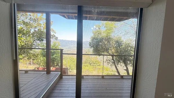 a view of a room with wooden floor and a window