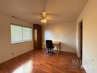 a view of a workspace with furniture and a window