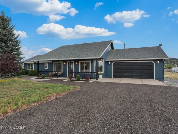 a front view of a house with yard and parking