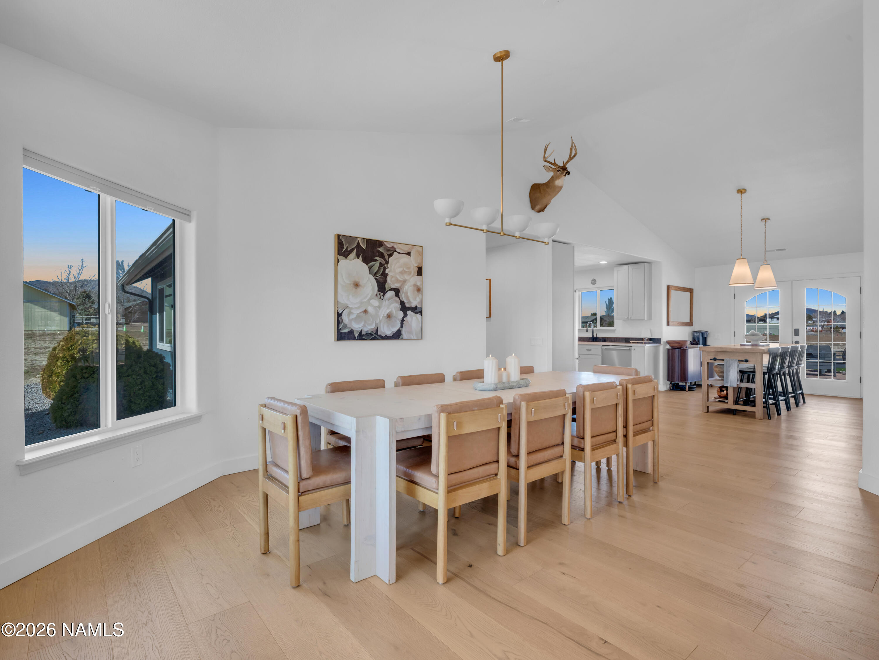 8115 Fawn Run Road Flagstaff, AZ 86004 - Photo 11 of 26 a dining room with wooden floor a chandelier a wooden table and chairs