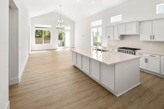 a large kitchen with kitchen island wooden floors and stainless steel appliances