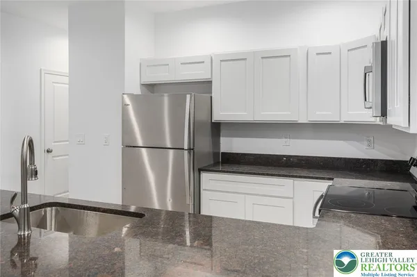a view of kitchen with stainless steel appliances granite countertop a sink and a stove