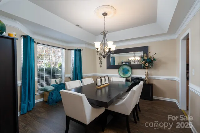 a dining room with furniture a chandelier and wooden floor