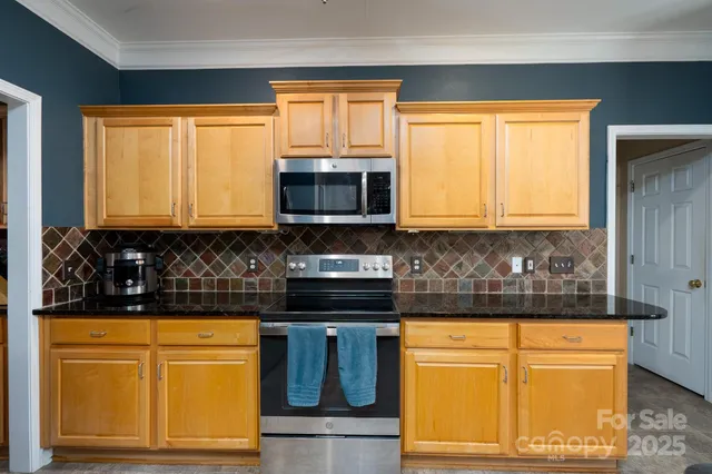 a kitchen with stainless steel appliances granite countertop cabinets and a window