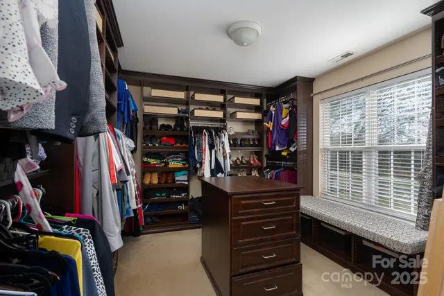 a view of walk in closet with clothes and shoes