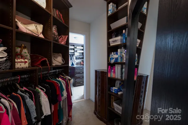a view of walk in closet with clothes and shoes