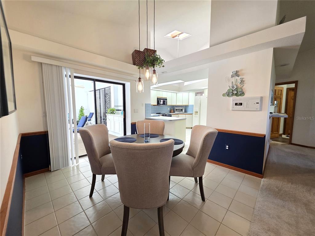 9446 Ashley Drive Weeki Wachee, FL 34613 - Photo 12 of 45 a view of a dining room with furniture a chandelier and large windows