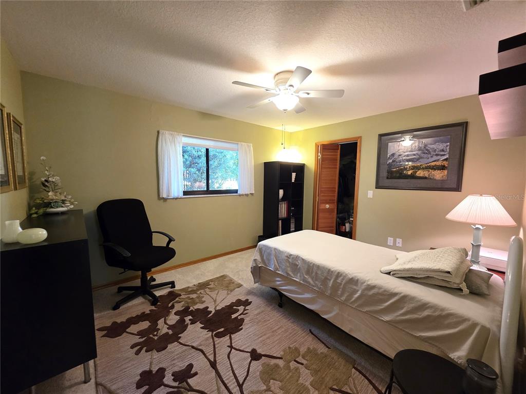 9446 Ashley Drive Weeki Wachee, FL 34613 - Photo 17 of 45 a bedroom with a bed and a chandelier