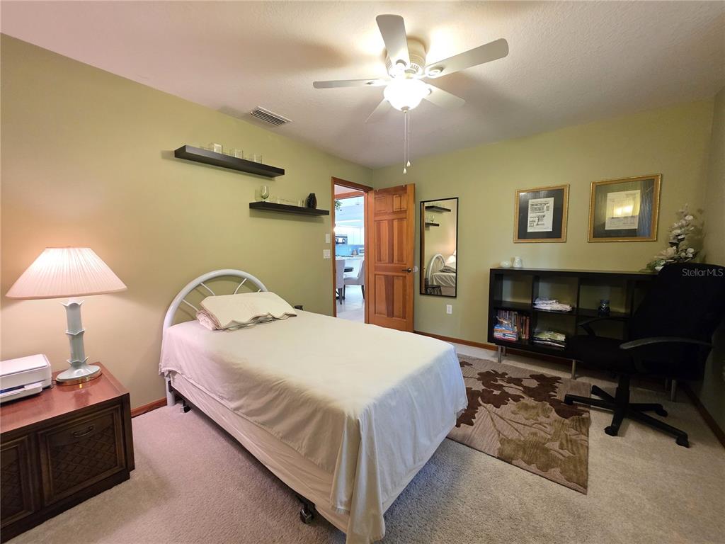 9446 Ashley Drive Weeki Wachee, FL 34613 - Photo 18 of 45 a spacious bedroom with a bed a table and chair