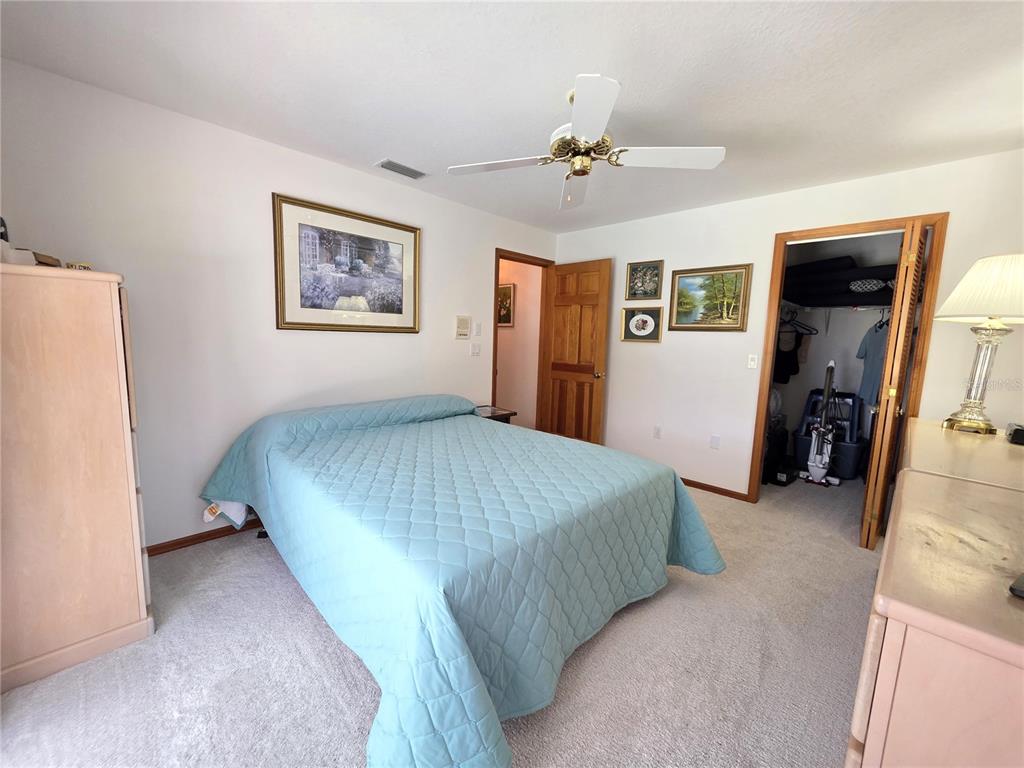 9446 Ashley Drive Weeki Wachee, FL 34613 - Photo 21 of 45 a bedroom with a bed and a chandelier