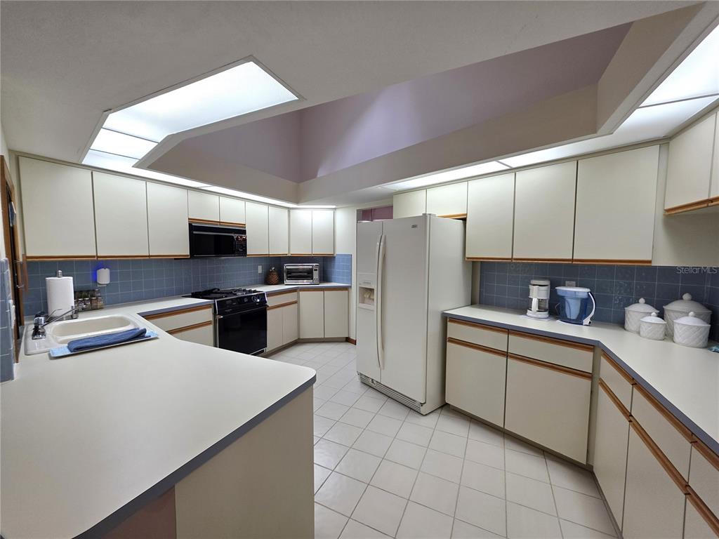 9446 Ashley Drive Weeki Wachee, FL 34613 - Photo 8 of 45 a kitchen with a sink stainless steel appliances and white cabinets