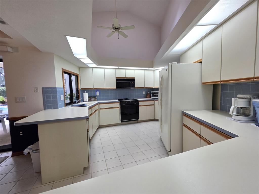 9446 Ashley Drive Weeki Wachee, FL 34613 - Photo 9 of 45 a kitchen with kitchen island a counter top space stainless steel appliances and cabinets