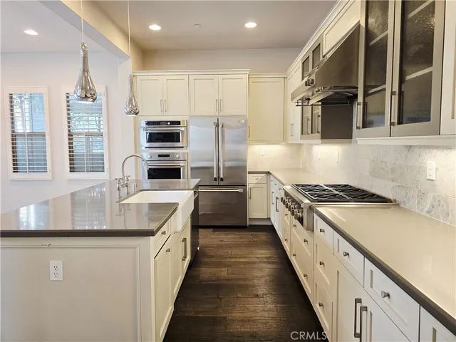 a kitchen with stainless steel appliances granite countertop a stove a sink and a refrigerator