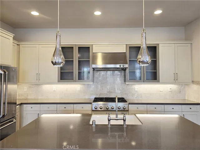 a kitchen with stainless steel appliances granite countertop a sink a stove counter space and cabinets