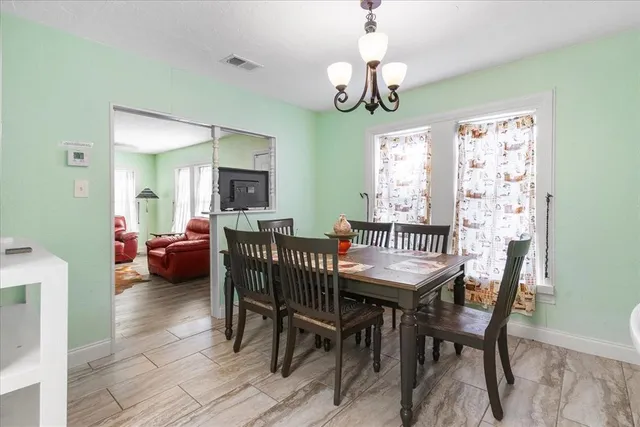 a view of a dining room with furniture a chandelier and wooden floor