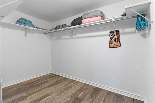 a view of walk in closet with empty racks